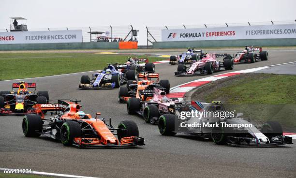 Lance Stroll of Canada driving the Williams Martini Racing Williams FW40 Mercedes battles with Fernando Alonso of Spain driving the McLaren Honda...