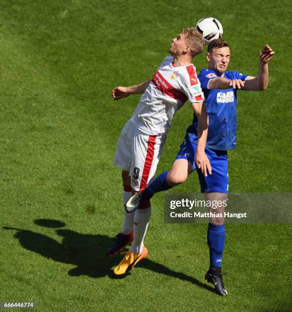 Simon Terodde of Stuttgart jumps for a header with Benedikt Gimber of Karlsruhe during the Second Bundesliga match between VfB Stuttgart and...