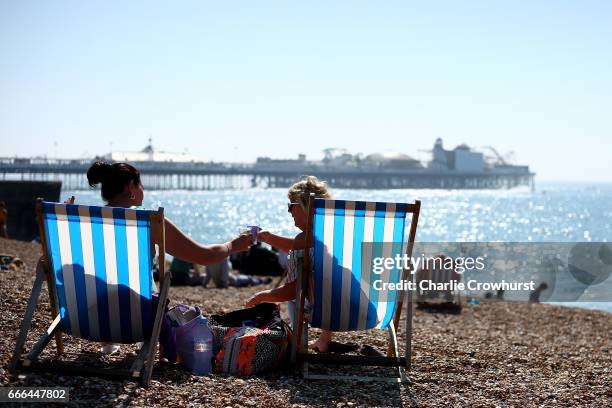 Couple a ladies cheers a drinks in their deck chairs on the hottest weekend of the year so far on April 9, 2017 in Brighton, England. Temperatures...