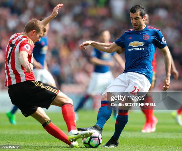 Sunderland's Swedish midfielder Sebastian Larsson vies with Manchester United's Armenian midfielder Henrikh Mkhitaryan during the English Premier...