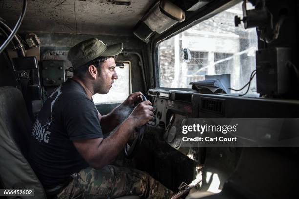 Member of the Iraqi security forces drives a Humvee with bullet damaged windows in west Mosul on April 7, 2017 in Mosul, Iraq. Iraqi forces backed by...