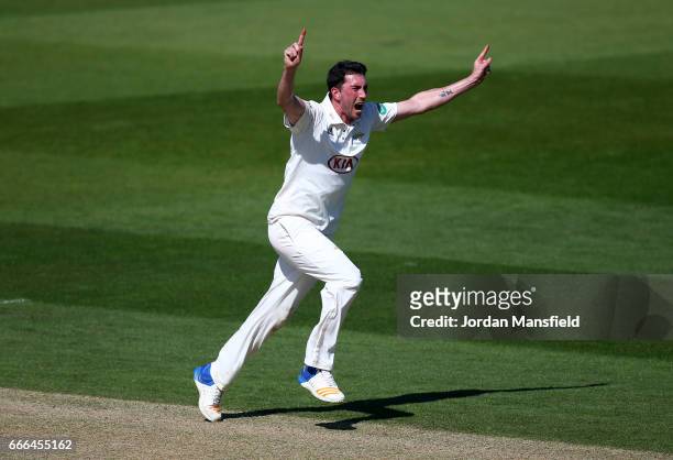 Mark Footitt of Surrey celebrates getting the wicket of Ian Bell of Warwickshire off a catch from Scott Borthwick of Surrey during day three of the...