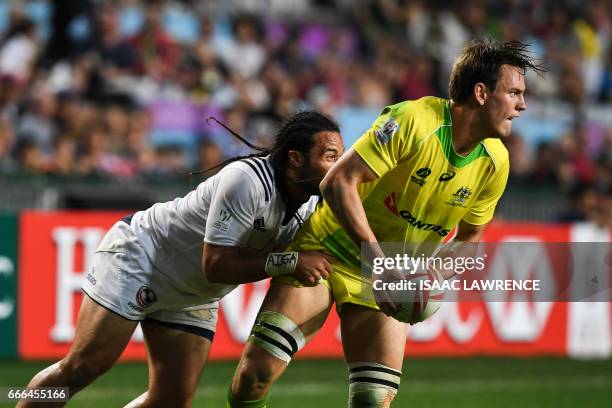 Lachie Anderson of Australia looks to pass the ball as Mike Te'o of the US makes a tackle during the bronze medal match on the third and final day of...