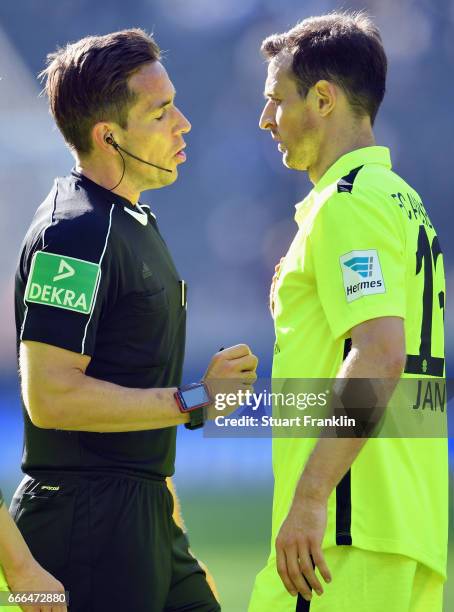 Referee Tobias Stieler talks to Christoph Janker of Augsburg during the Bundesliga match between Hertha BSC and FC Augsburg at Olympiastadion on...