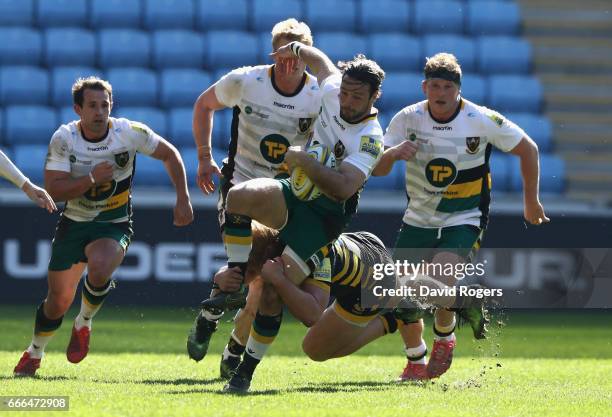 Ben Foden of Northampton breaks away from the challenge by Tommy Taylor during the Aviva Premiership match between Wasps and Northampton Saints at...