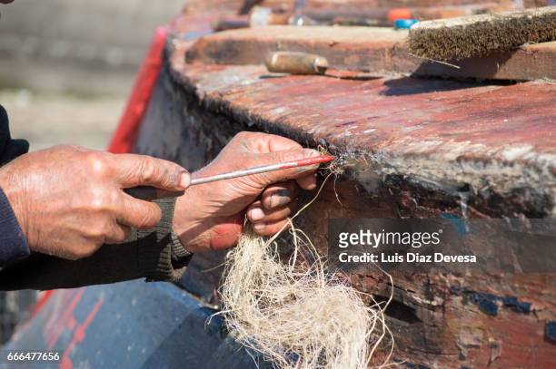 repairing a leak on the boat's hull - hombres mayores 個照片及圖片檔