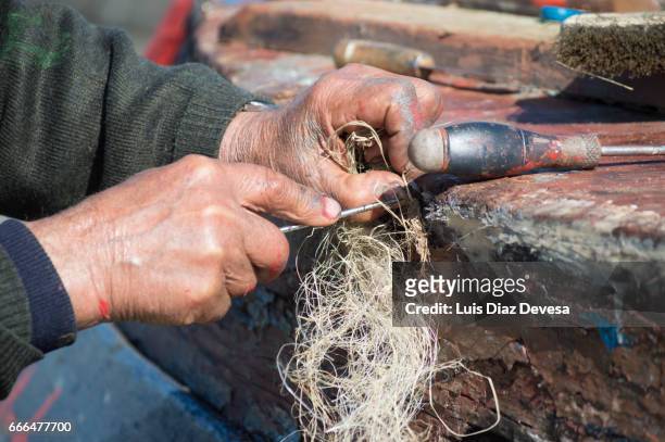 repairing a leak on the boat's hull - mano umana stock pictures, royalty-free photos & images