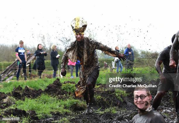 Man dressed as the Pope makes his way around the course as competitors take part in the annual McVities Mud Madness 8km cross country run on April 9,...