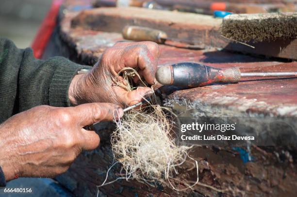 repairing a leak on the boat's hull - cuestiones ambientales 個照片及圖片檔