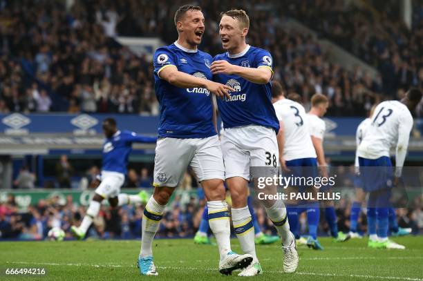 Everton's English defender Phil Jagielka celebrates scoring his team's third goal with Everton's English defender Matthew Pennington during the...