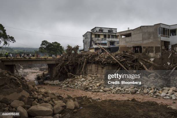 Displaced residents walk across a bridge over the Mocoa River after a landslide in Mocoa, Putumayo, Colombia, on Monday, April 3, 2017. Torrential...