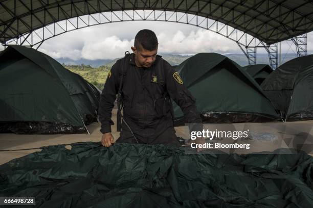Police officer sets up tents at a disaster relief center after landslides in Mocoa, Putumayo, Colombia, on Monday, April 3, 2017. Torrential rains...