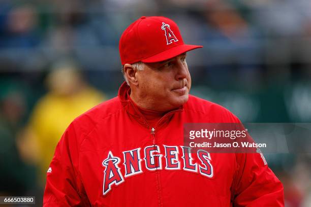 Mike Scioscia of the Los Angeles Angels of Anaheim stands outside the dugout during the sixth inning against the Oakland Athletics at the Oakland...