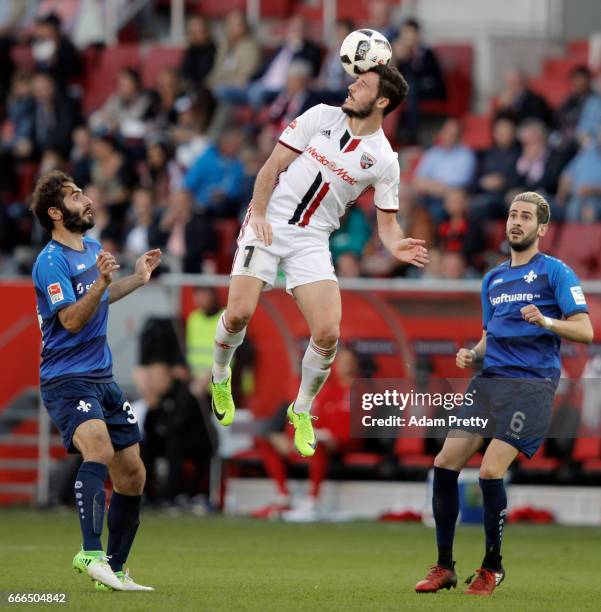 Mathew Leckie of Ingolstadt jumps for the ball between Hamit Altintop and Mario Vrancic of Darmstadt during the Bundesliga match between FC...