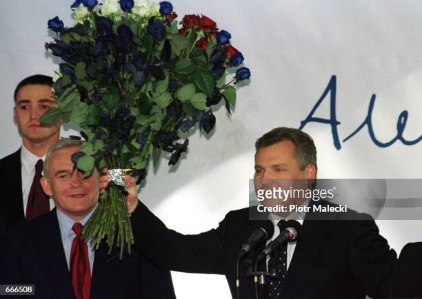 Aleksander Kwasniewski holds a bunch of flowers October 8, 2000 in Warsaw while celebrating after winning a second term in office as Polish...