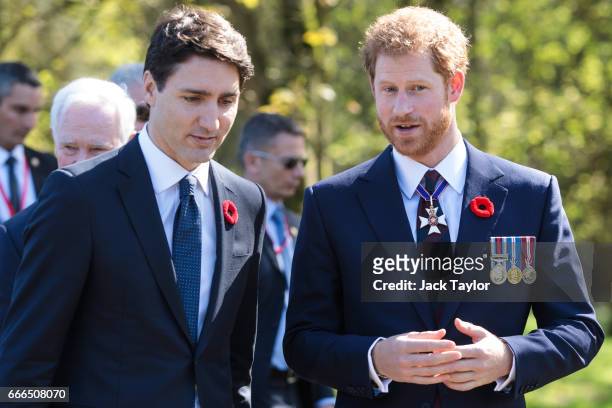 Canadian Prime Minister Justin Trudeau and Prince Harry leave following a tour of the preserved trenches at Vimy Memorial Park on April 9, 2017 in...