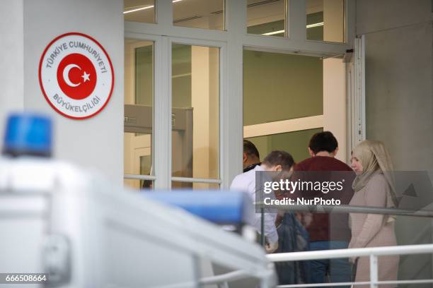 People are seen waiting outside the Turkish embassy in Warsaw on 9 April, 2017. A week ahead of the referendum in Turkey people are allowed to place...