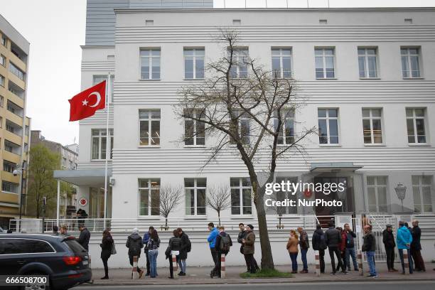 People are seen waiting outside the Turkish embassy in Warsaw on 9 April, 2017. A week ahead of the referendum in Turkey people are allowed to place...