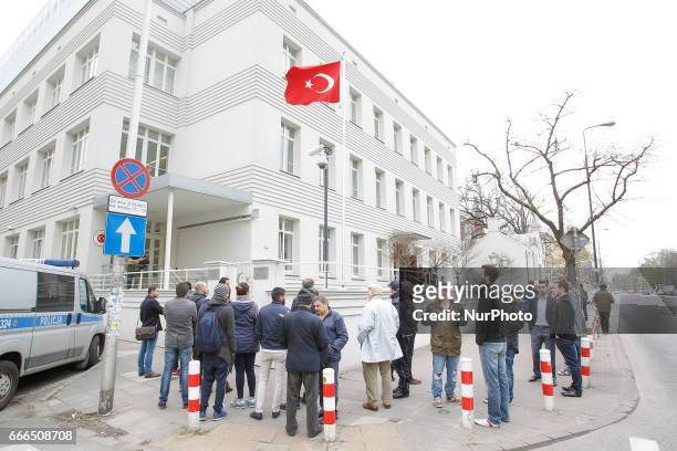 People are seen waiting outside the Turkish embassy in Warsaw on 9 April, 2017. A week ahead of the referendum in Turkey people are allowed to place...