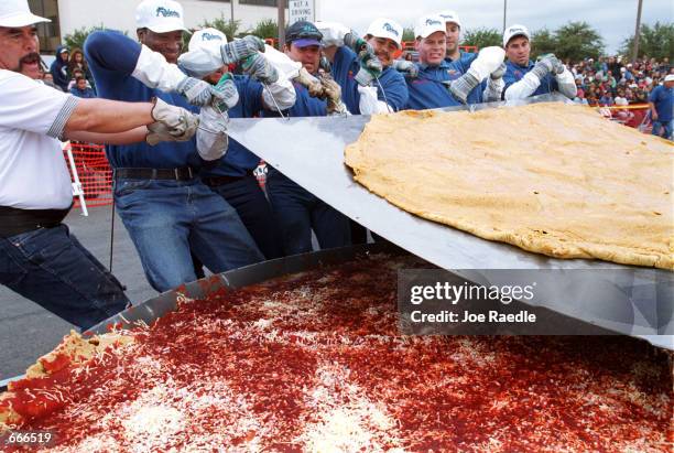 Robert Estrada and others maneuver a tortilla into place October 8, 2000 as they make an attempt to set the Guinness World Record for the world's...