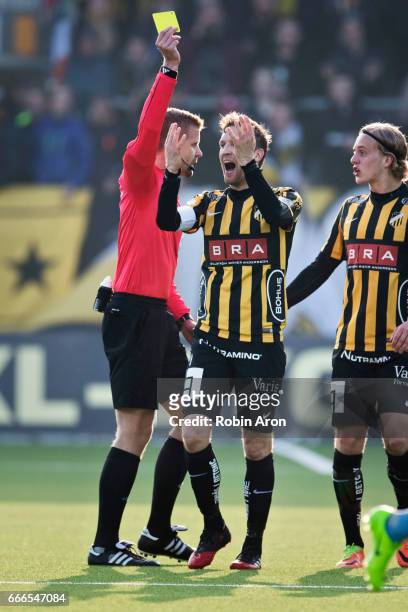 Referee Glenn Nyberg hand out yellow card to Rasmus Lindgren of BK Hacken after contact with Karim Mrbati of Djurgardens IF during the Allsvenskan...