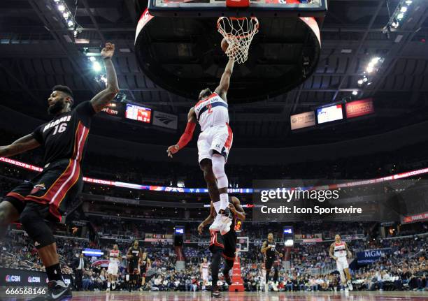 Washington Wizards guard John Wall scores in the first half against Miami Heat forward James Johnson on April 8 at the Verizon Center in Washington,...