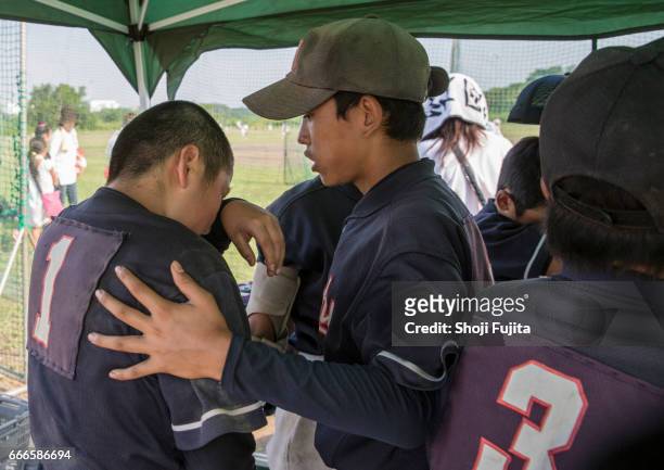 youth baseball players, buddies - one friend helping two other imagens e fotografias de stock
