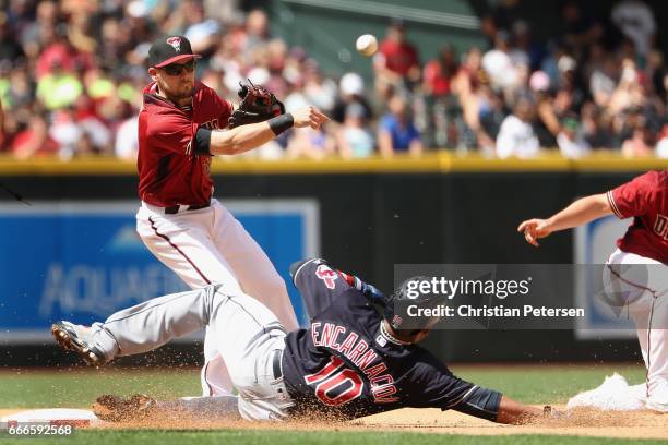 Infielder Chris Owings of the Arizona Diamondbacks throws over the sliding Edwin Encarnacion of the Cleveland Indians attempting an unsuccessful...