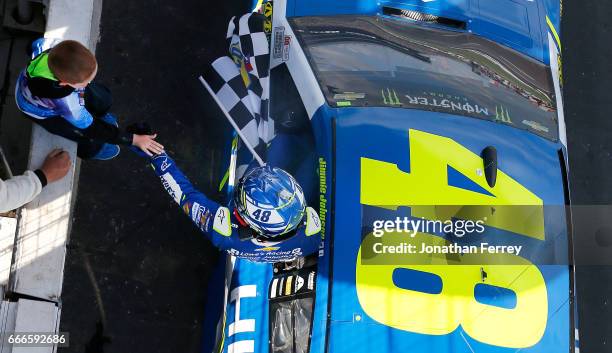 Jimmie Johnson, driver of the Lowe's Chevrolet, high fives a young race fan after winning the Monster Energy NASCAR Cup Series O'Reilly Auto Parts...