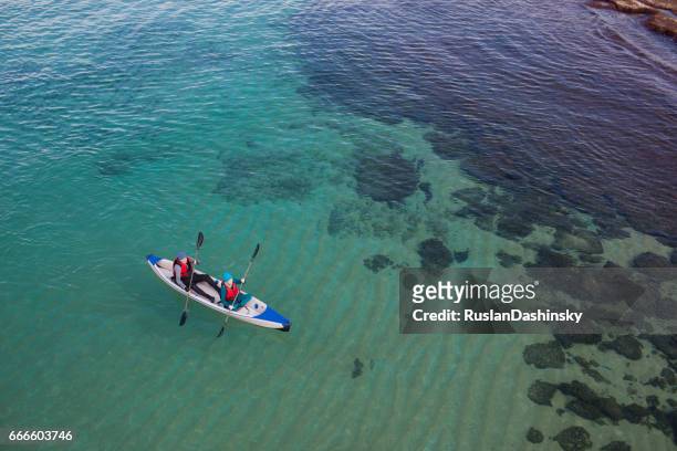 mature couple's kayak sea challenge (aerial photography). - kayaking aerial stock pictures, royalty-free photos & images
