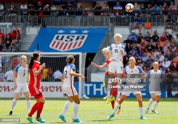 Megan Rapinoe of U.S. Heads the ball over Anna Cholovyaga of Russia at midfield in the second half during the International Friendly soccer match at...