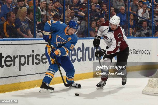 Vladimir Tarasenko of the St. Louis Blues and Patrick Wiercioch of the Colorado Avalanche battle for the puck on April 9, 2017 at Scottrade Center in...