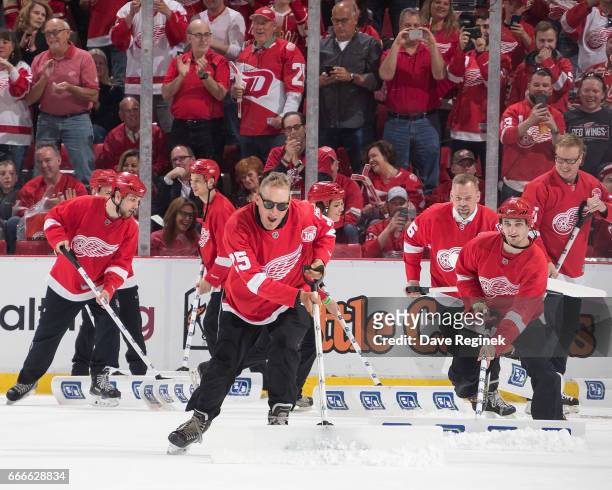 From L to R Former Detroit Red Wings Darren McCarty, Tomas Holmstrom, and Larry Murphy take a turn as ice crew during a stoppage of play in an NHL...