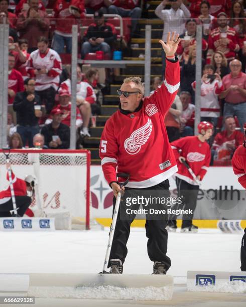 Former Detroit Red Wing Darren McCarty waves to the crowd as he shovels the ice during a stoppage of play in an NHL game against the New Jersey...
