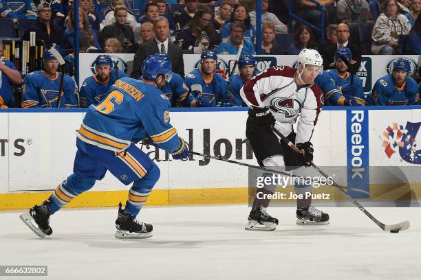 Joel Edmundson of the St. Louis Blues defends against Mikhail Grigorenko of the Colorado Avalanche on April 9, 2017 at Scottrade Center in St. Louis,...