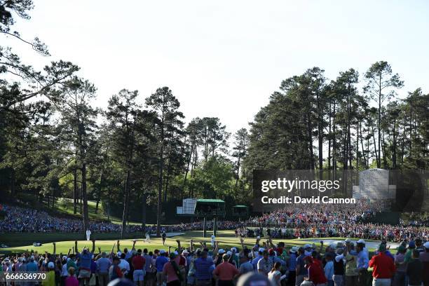 Patrons cheer as Sergio Garcia of Spain celebrates making a putt for eagle on the 15th hole during the final round of the 2017 Masters Tournament at...