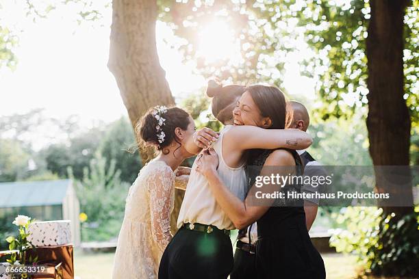 newlywed lesbian couple being congratulated - wedding guest stock-fotos und bilder