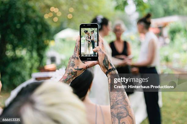 woman taking photo at wedding - handy foto stock-fotos und bilder