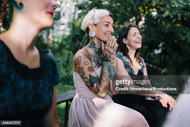 wedding guest looks on as friends get married - wedding guests stockfoto's en -beelden