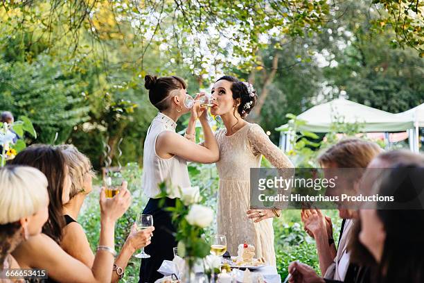 newlywed lesbian couple drinking - adorno floral fotografías e imágenes de stock