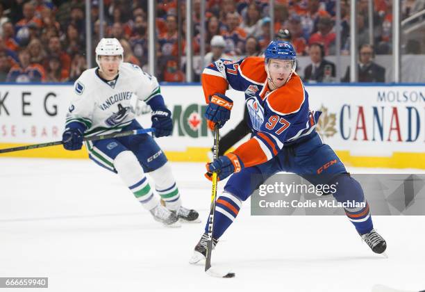 Connor McDavid of the Edmonton Oilers is pursued by Drew Shore of the Vancouver Canucks on April 9, 2017 at Rogers Place in Edmonton, Alberta, Canada.