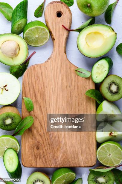 oak wood cutting board  with fresh organic green fruits and vegetables - cutting green apple stock pictures, royalty-free photos & images