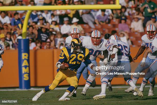 American football running back Eric Dickerson , pictured in action with the ball playing for the Los Angeles Rams against the Houston Oilers at the...