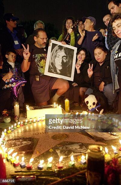 Fans show the peace sign and sing "Happy Birthday" in rememberance of John Lennon on what would have been the slain Beatle's 60th birthday, October 9...
