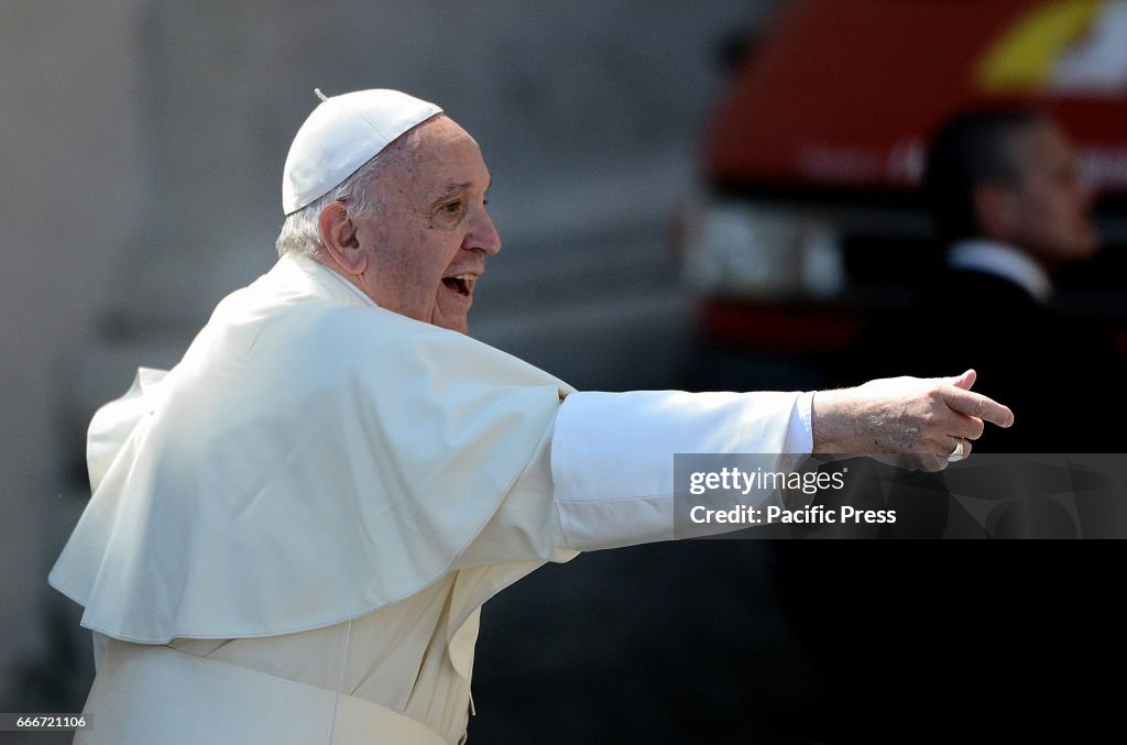 Pope Francis waves to the people who attended the Palm...