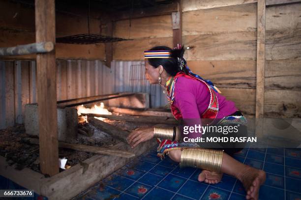 This picture taken on April 9, 2017 shows Anat Ugom from a sub-tribe of the Bidayuhs indigenous group, wearing traditional yellow copper rings called...