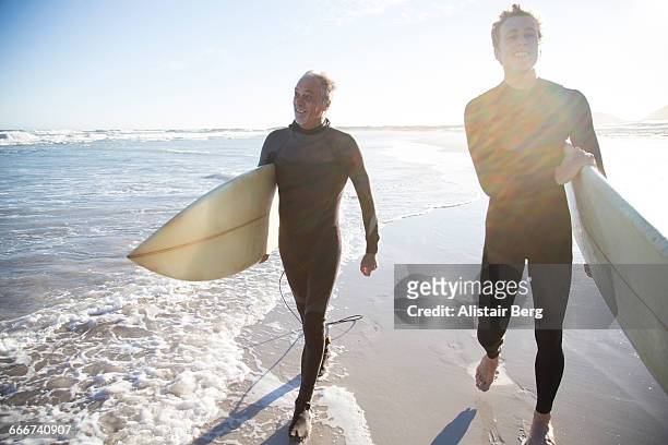 father and son going surfing together - 20 24 anni foto e immagini stock