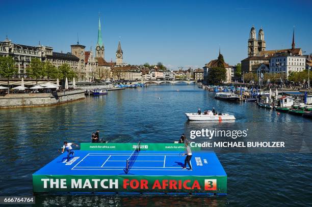 Swiss tennis superstar Roger Federer returns a ball to world number one Britain's Andy Murray during a promotion on a raft on the river Limmat before...