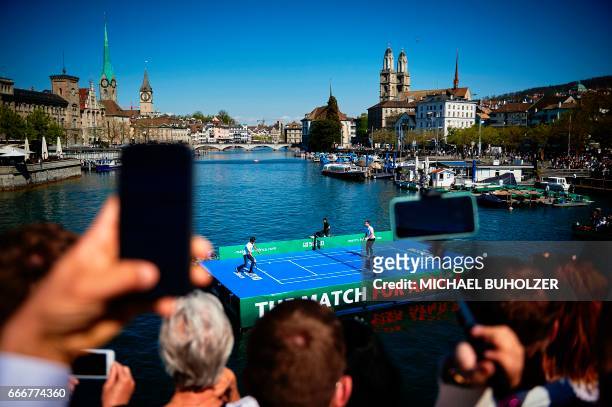 Swiss tennis superstar Roger Federer returns a ball to world number one Britain's Andy Murray during a promotion on a raft on the river Limmat before...