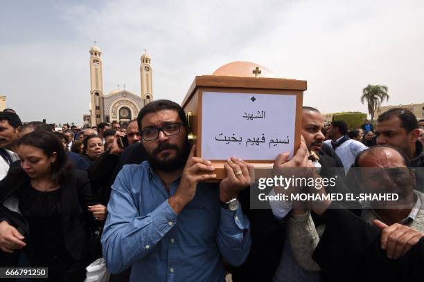 Mourners carry the coffin of a victim of the blast at the Coptic Christian Saint Mark's church in Alexandria the previous day during a funeral...